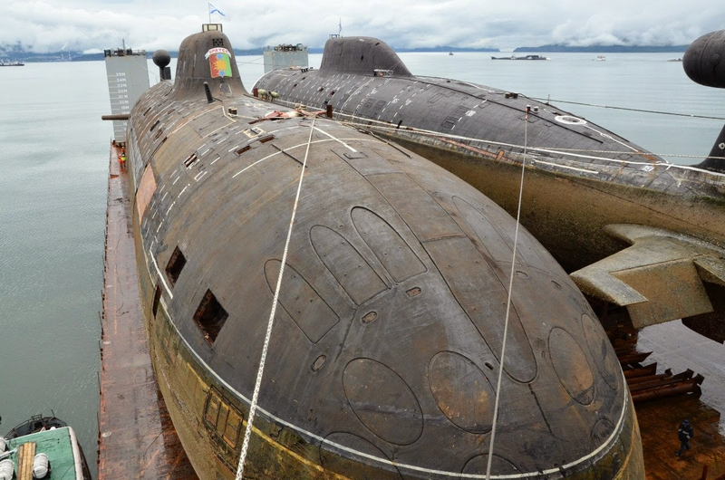 Two Akulas aboard a heavy-life vessel being transported from the Pacific for repairs. The Bratsk is on the left with Samara on the right. The size of the Akula is evidenced by the man in the lower right.